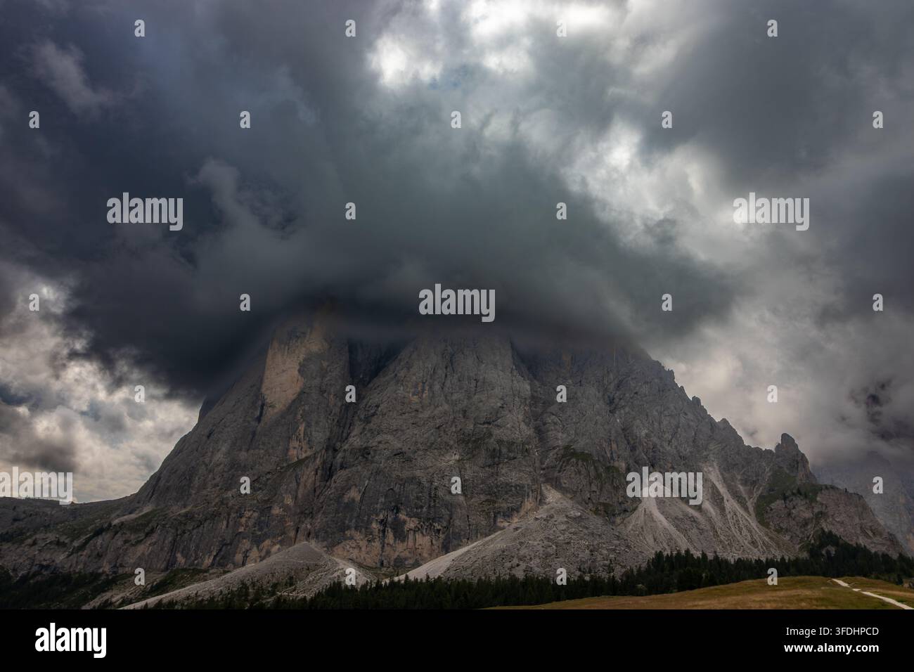 Nuvole di tempesta epiche e atmosferiche che avvolgono una vetta maestosa delle Dolomiti, ripresa grandangolare. Foto Stock