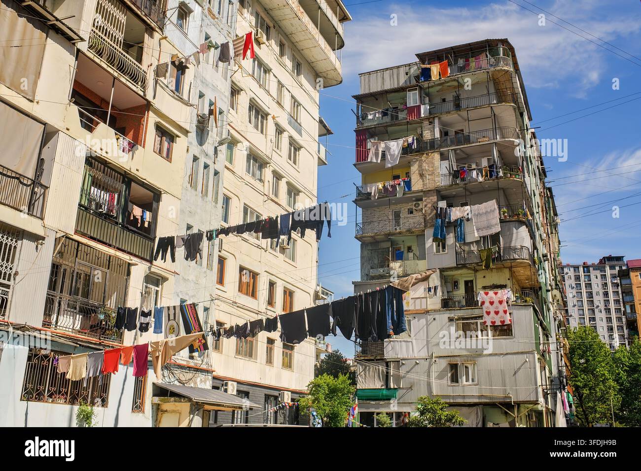 Batumi, Georgia - 20 maggio 2026: Biancheria stesa in massa su stendipendie tra palazzine residenziali in un cortile cittadino soleggiato Foto Stock
