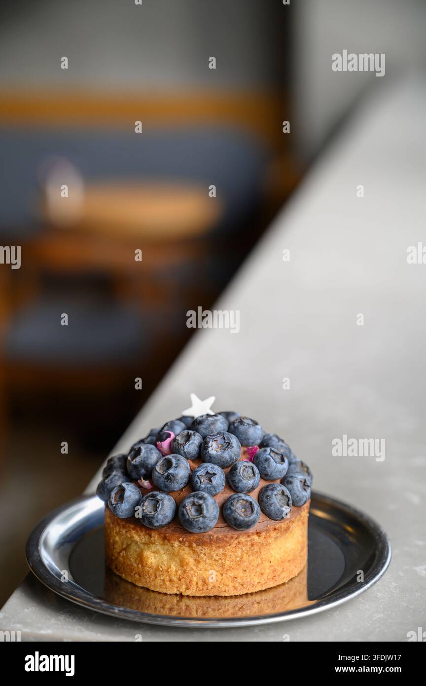 Torta di mirtilli ricoperta di mirtilli interi e ripieno cremoso Foto Stock
