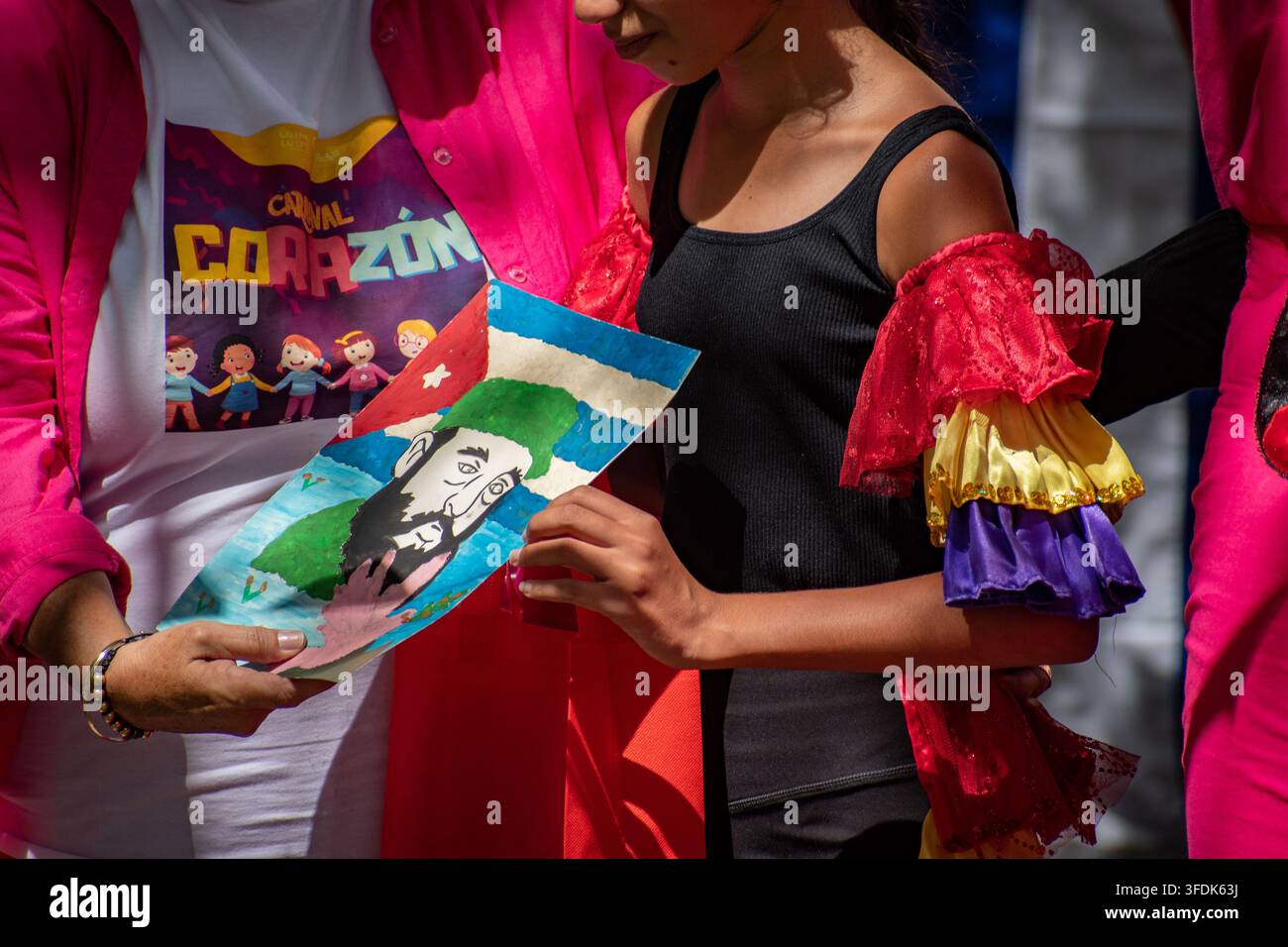 Giovane artista che tiene un disegno di Fidel Castro e della bandiera cubana durante l'evento El Carnavalito il 21 agosto 2026 a Ciego de Ávila, Cuba Foto Stock