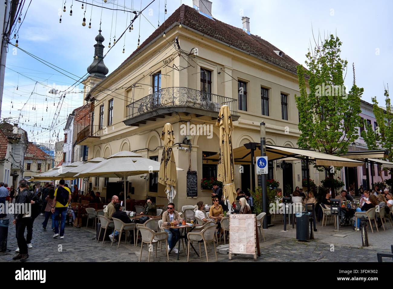 Cluj-Napoca, Romania. 19 apr., 2026: Turisti affollano un luogo popolare nel centro storico di Cluj-Napoca, all'incrocio tra Vasile Goldis e Sextil P Foto Stock
