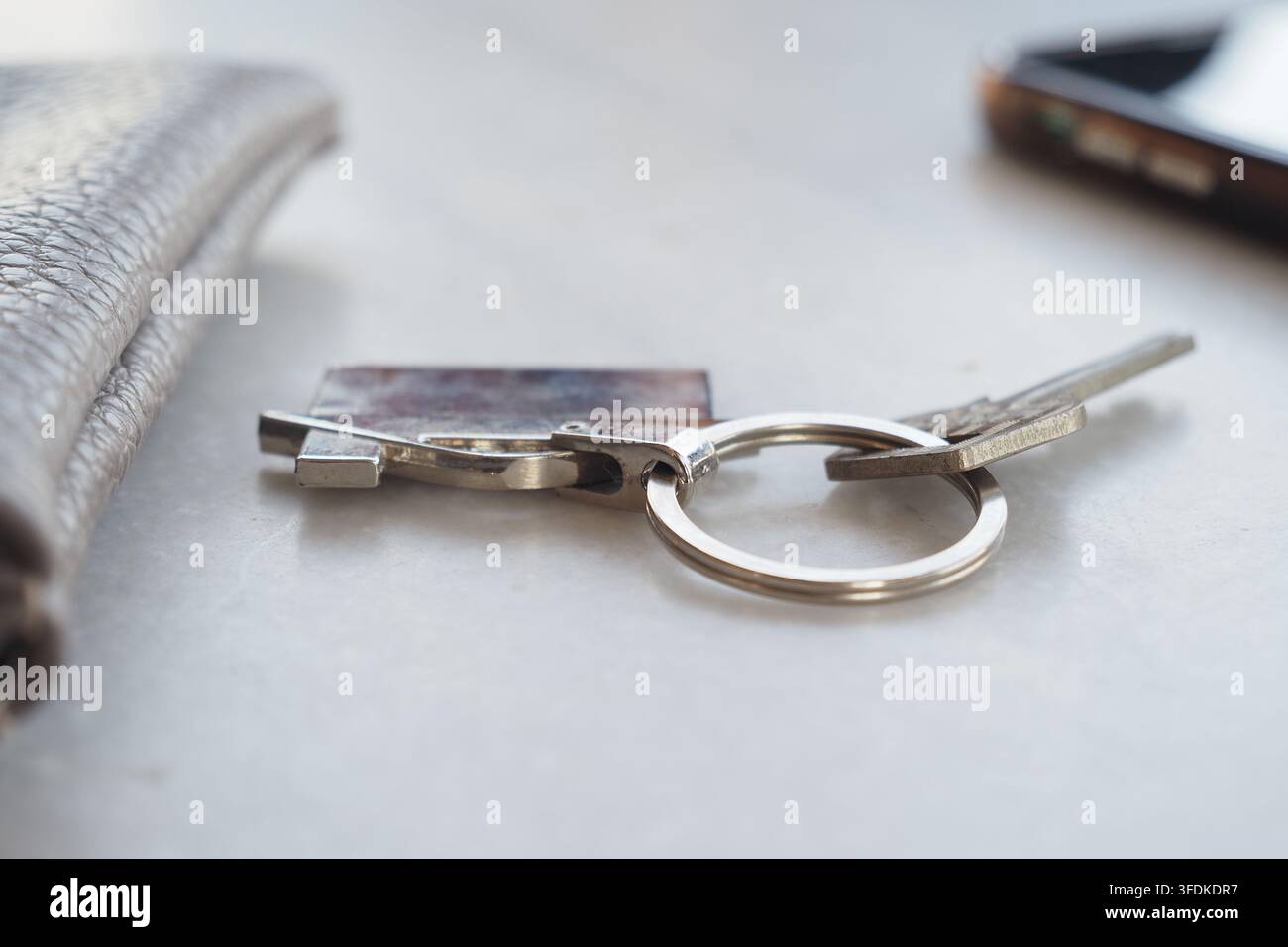 Chiavi e portafoglio su un tavolo accanto a un telefono cellulare Foto Stock