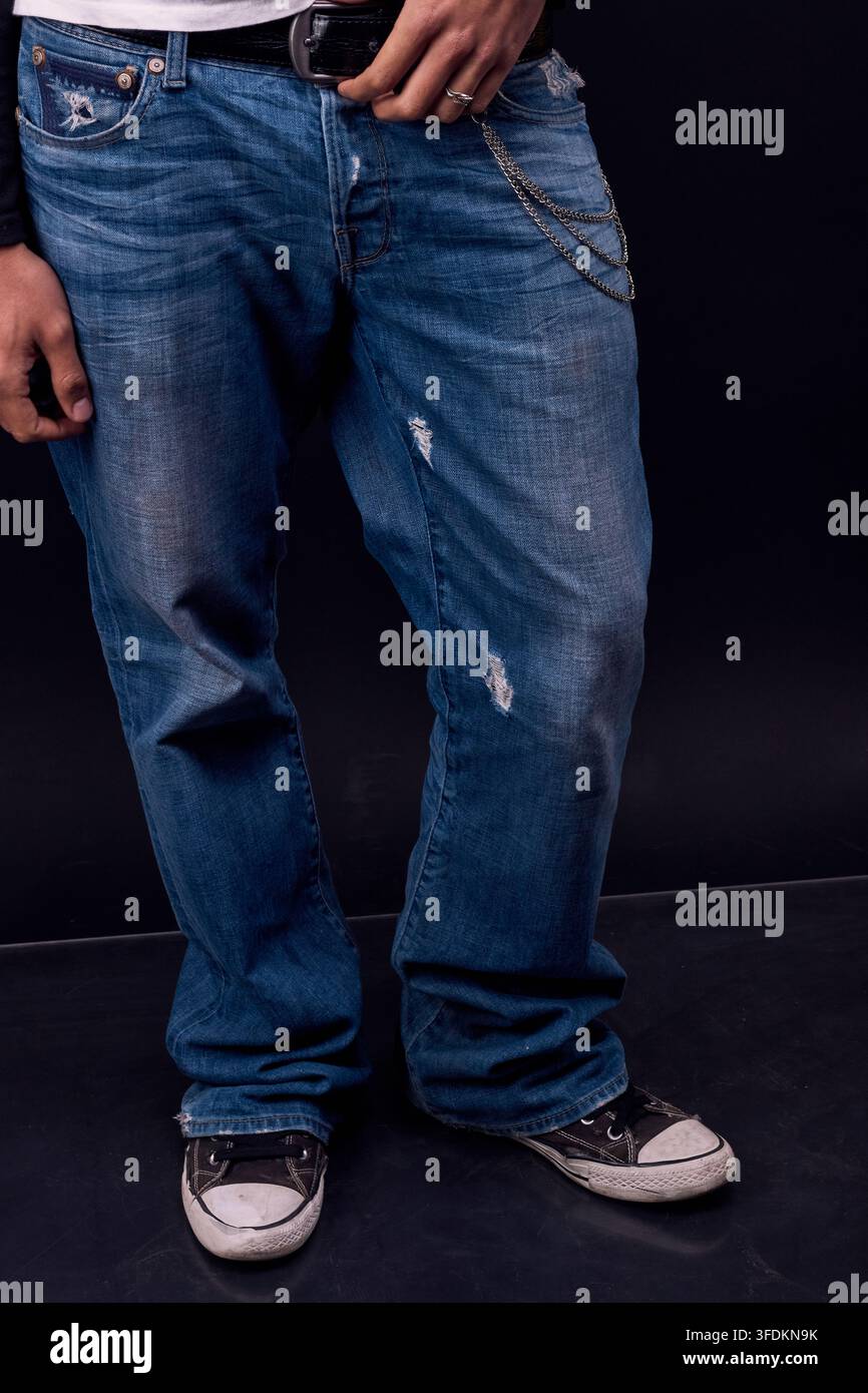 Gambe di un giovane che posa in studio, mostrando le sue gambe Foto Stock