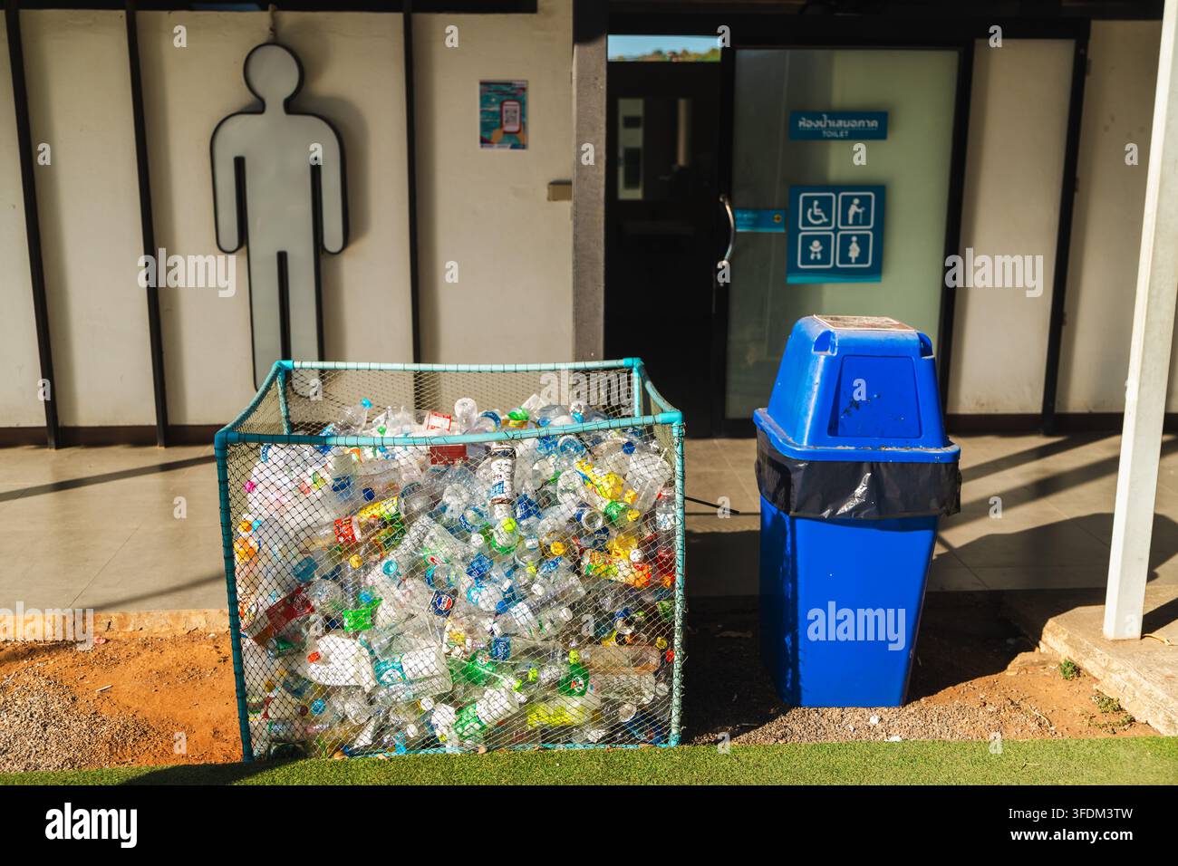 Cestino di riciclo per bottiglie di plastica davanti a un bagno accessibile Foto Stock