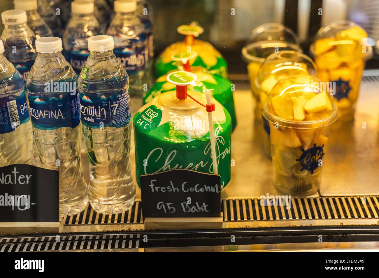 Espositore refrigerato di bevande di cocco fresche e coppette di frutta Foto Stock