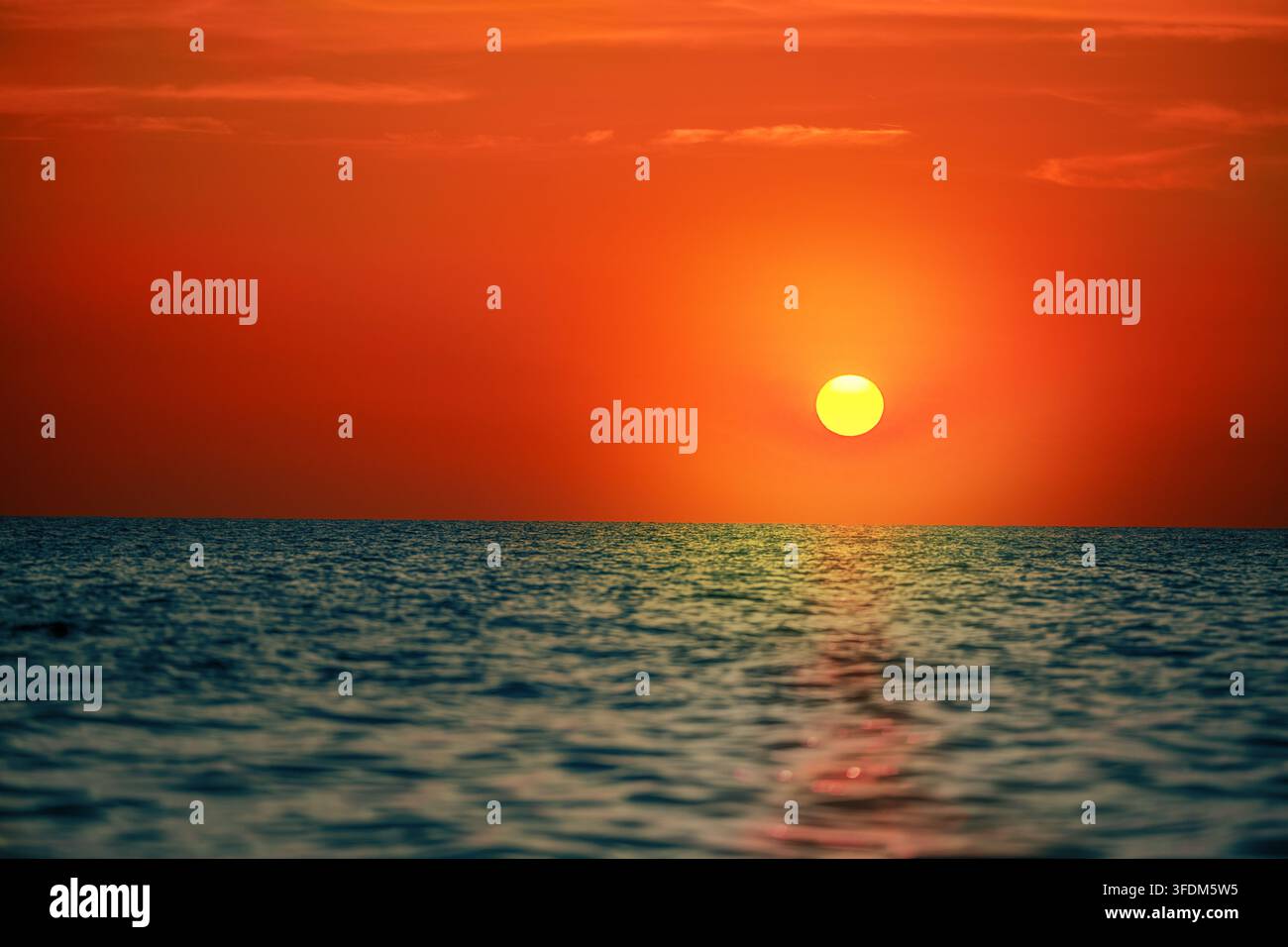 Tramonto arancione sull'orizzonte dell'oceano con mare calmo Foto Stock