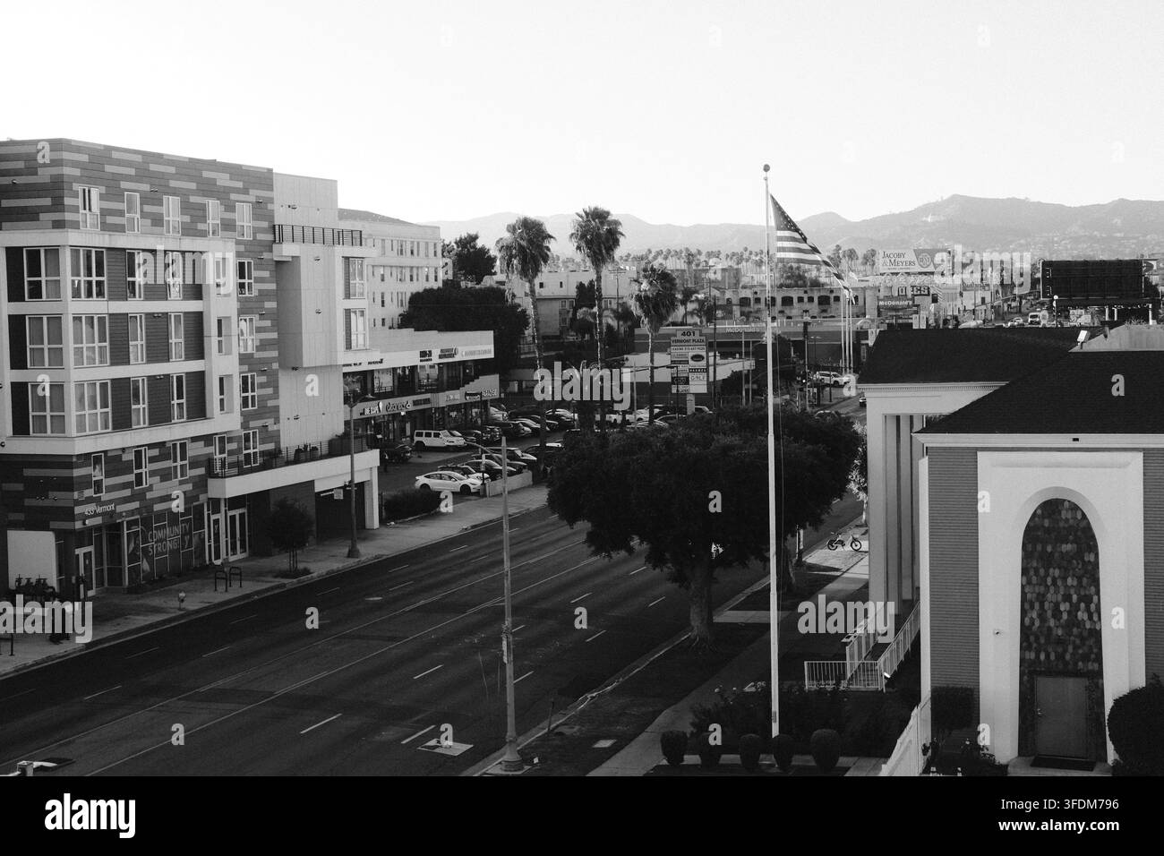 Vista elevata in bianco e nero su un quartiere del sud della California con edifici residenziali, strade e colline lontane. Foto Stock