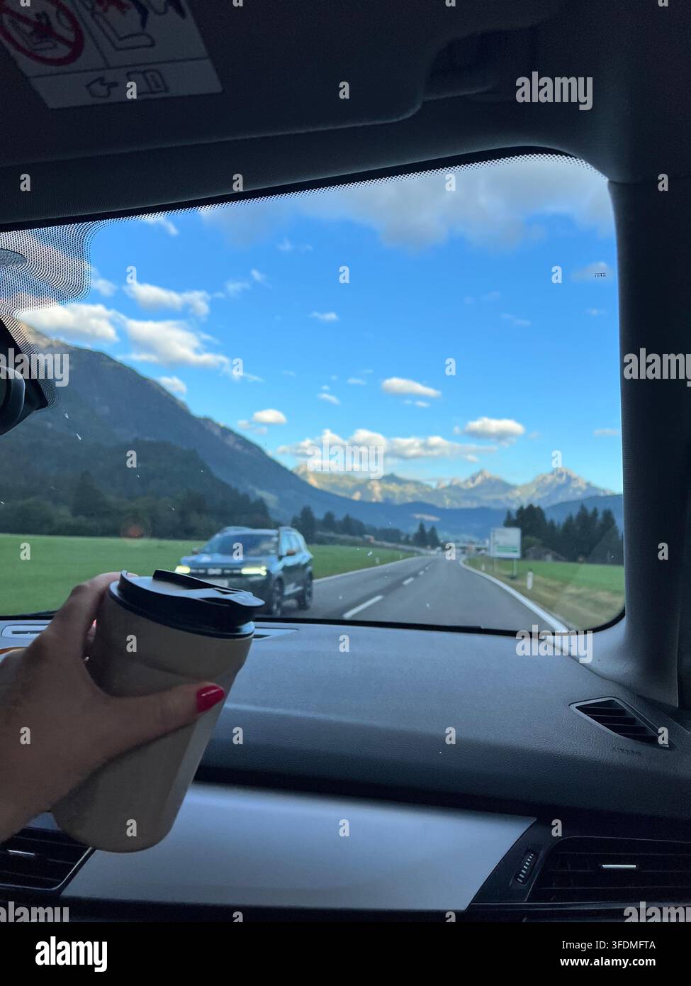 Strada panoramica attraverso le Alpi austriache, circondata da montagne, foreste sempreverdi e bellissimi paesaggi naturali, con auto che viaggiano lungo - Immagine stock catturata con smartphone