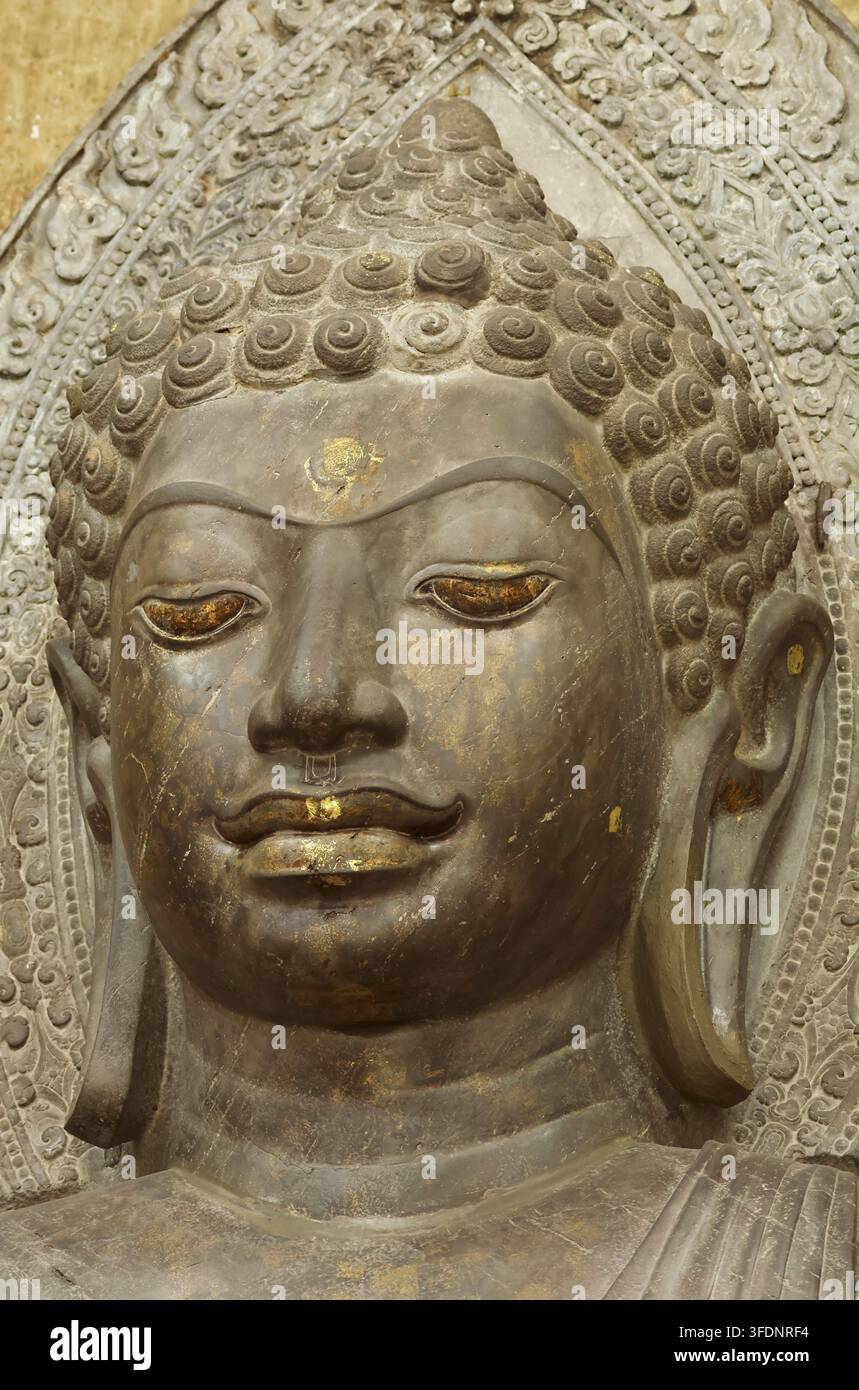 Prima piano del volto sereno di un'antica statua di Buddha in pietra verde al Wat Na Phra Meru, Ayutthaya, Thailandia Foto Stock