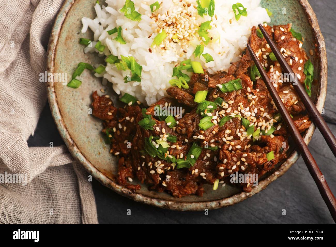 Bue bulgogi coreano con riso al gelsomino in una ciotola di ceramica fatta a mano Foto Stock