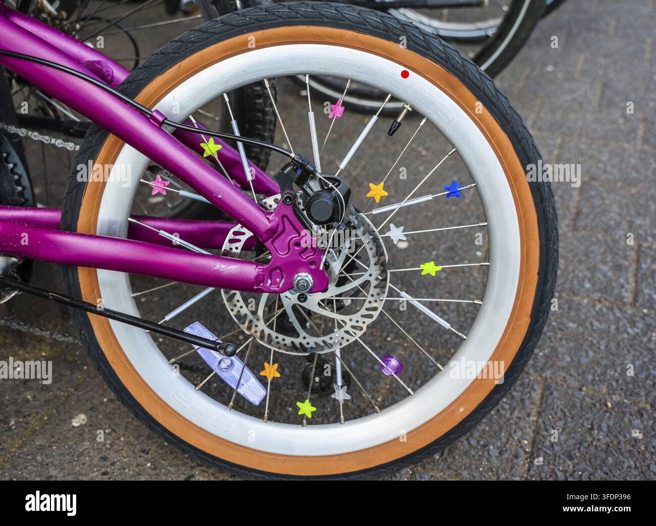 Bicicletta viola con stelle colorate come decorazione dei raggi Foto Stock