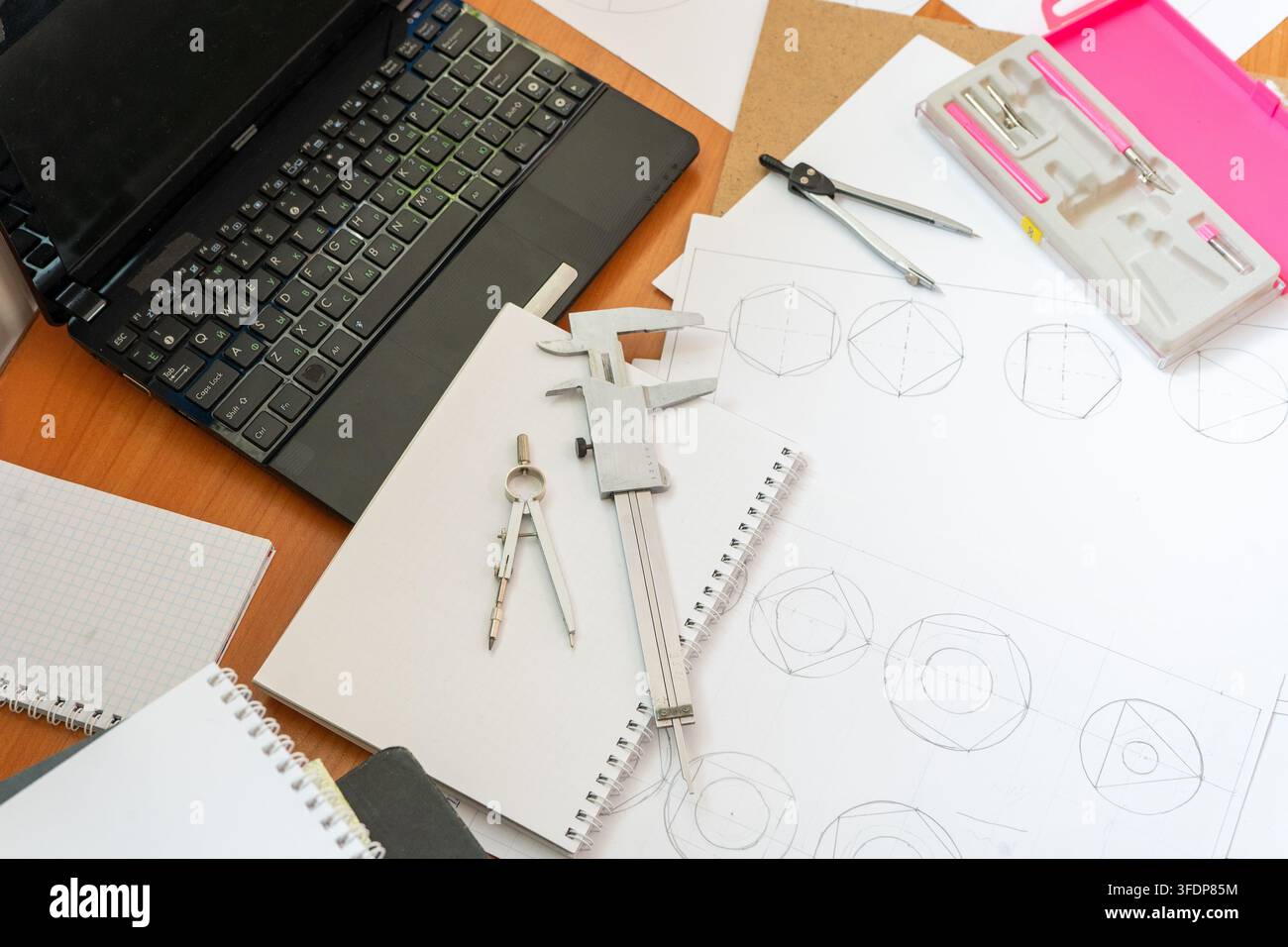 Spazio di lavoro dell'ingegnere Laptop, disegni tecnici, calibro a verniere, compasso Strumenti da tavolo Vista superiore scrivania da architetto schizzi geometrici squadri ingegneria e disegno tecnico. Sfondo di studio Foto Stock