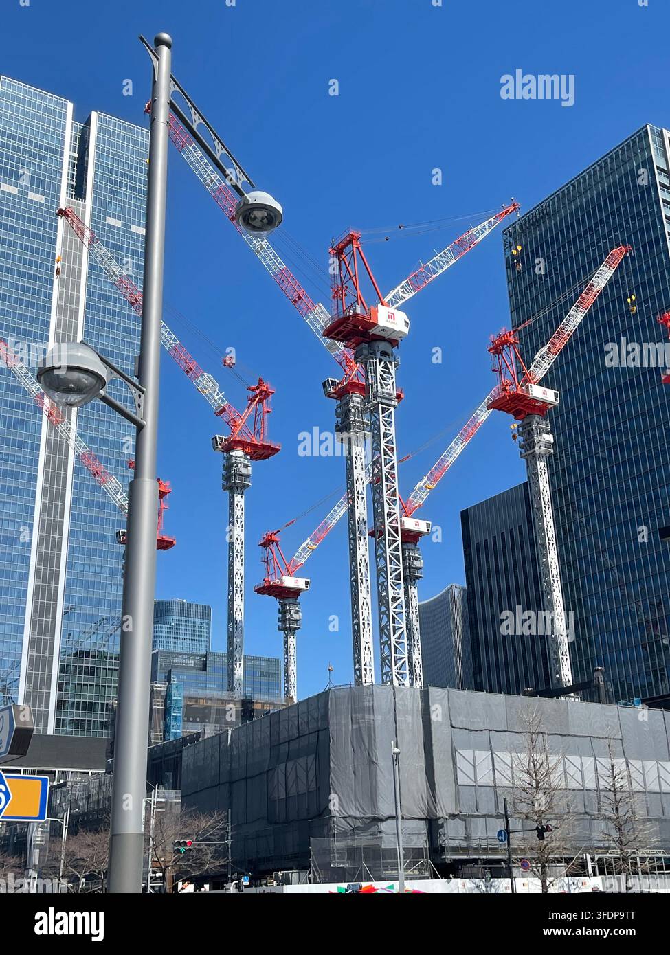 Grane costruzioni e grattacieli a Tokyo, Giappone, che rappresentano lo sviluppo urbano, la riqualificazione e la crescita moderna della città. - Immagine stock catturata con smartphone