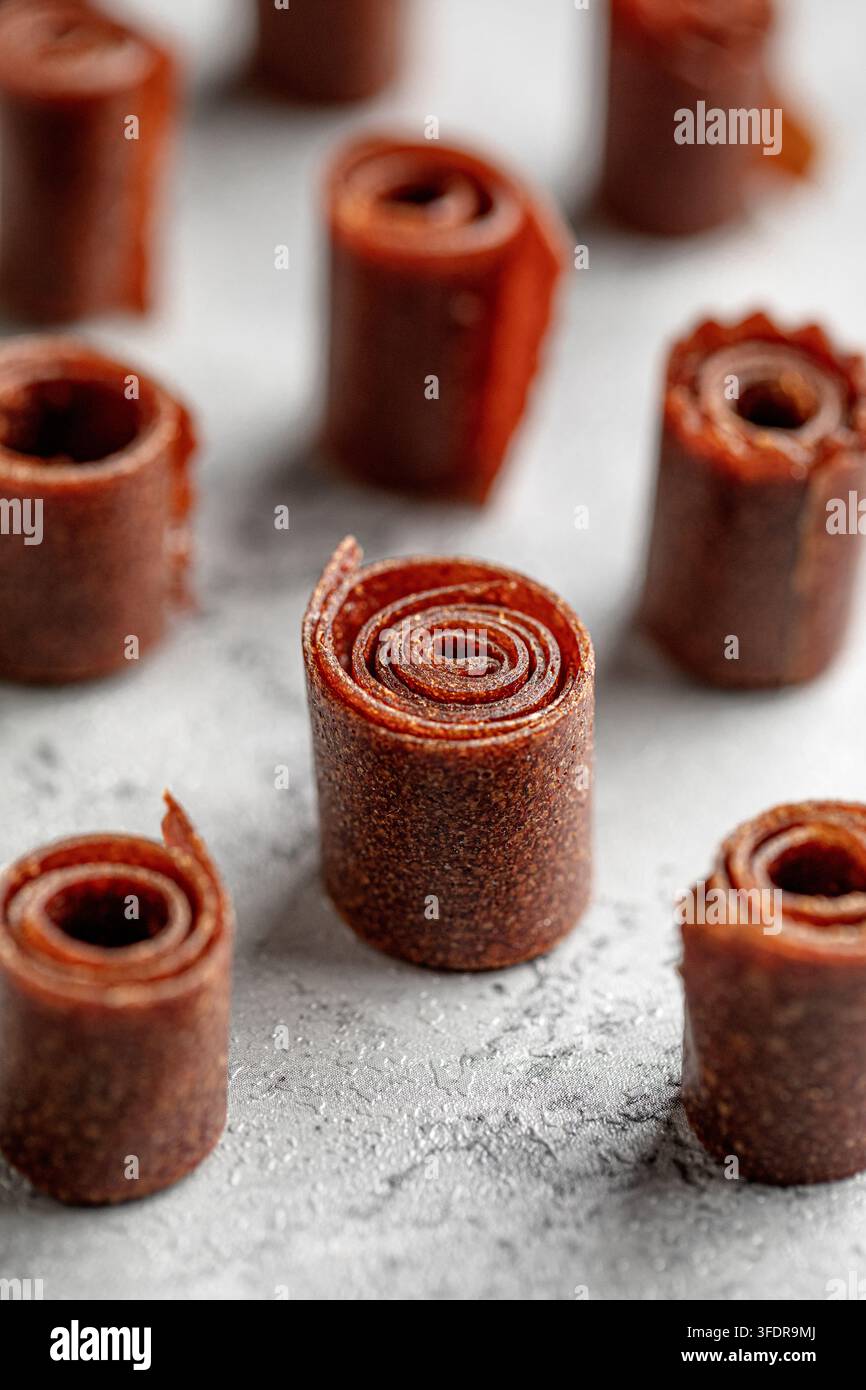 Rotoli di pelle di frutta alle mele fatti in casa su tavolo grigio Foto Stock