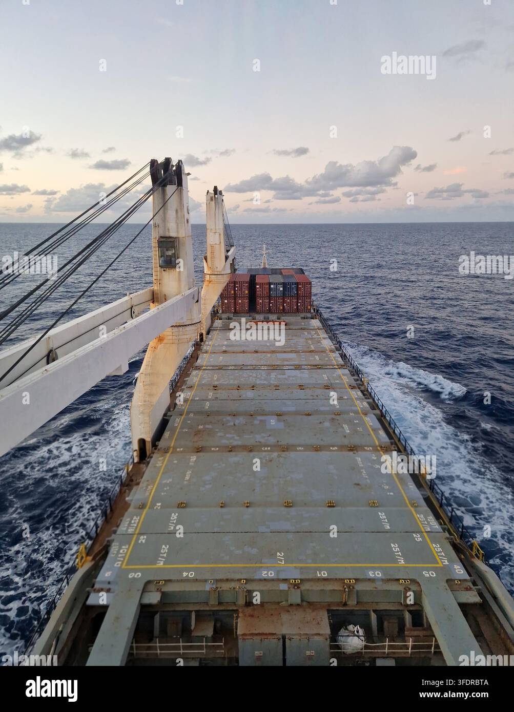 Nave portacontaineri che trasporti trasformatori industriali pesanti nella stiva e carico sul ponte durante operazioni logistiche marittime Foto Stock