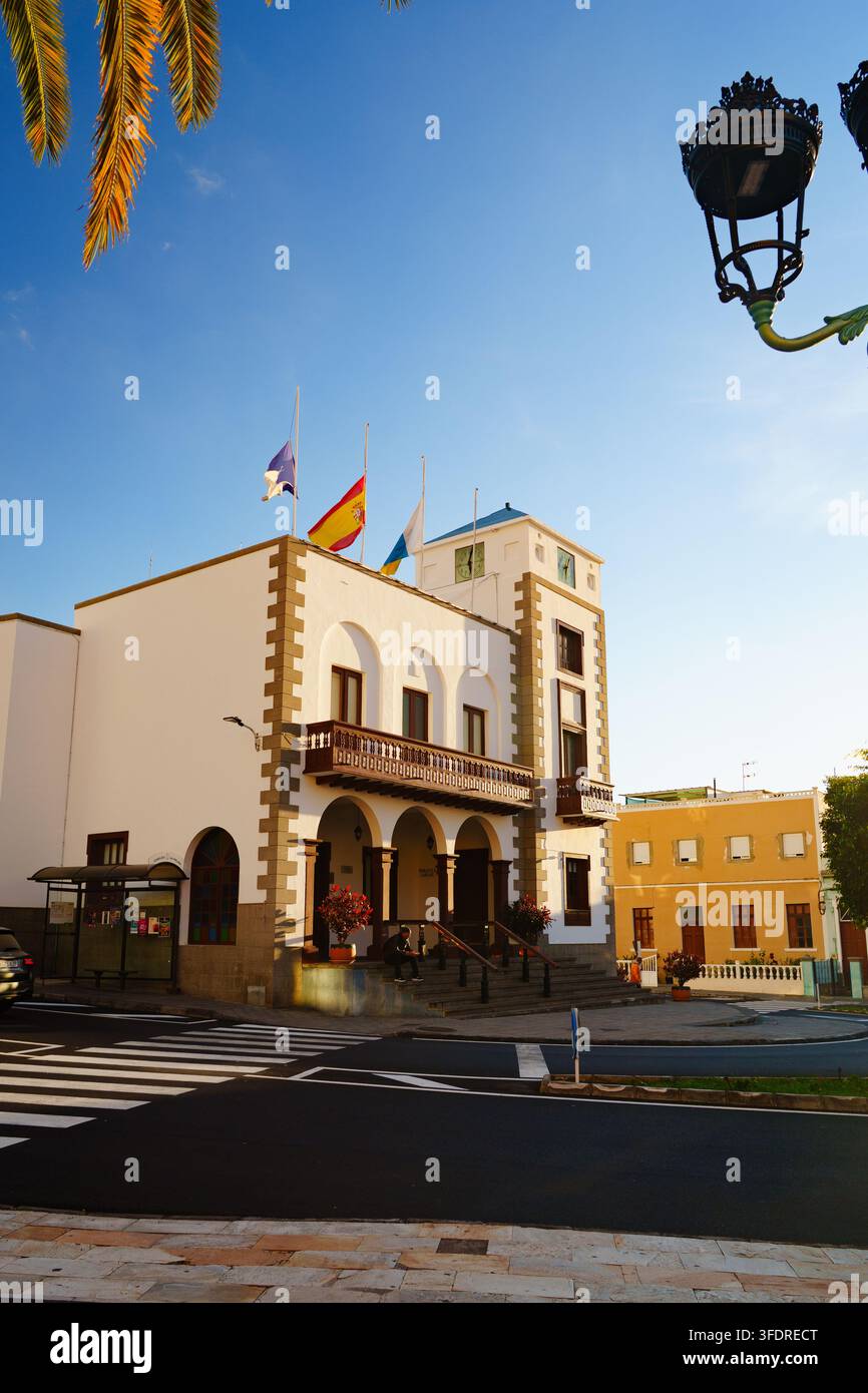 Bandiere spagnole, canarie e comunali sventolano a mezz'asta al bianco municipio di Villa de Tazacorte, La Palma, Isole Canarie, Spagna Foto Stock