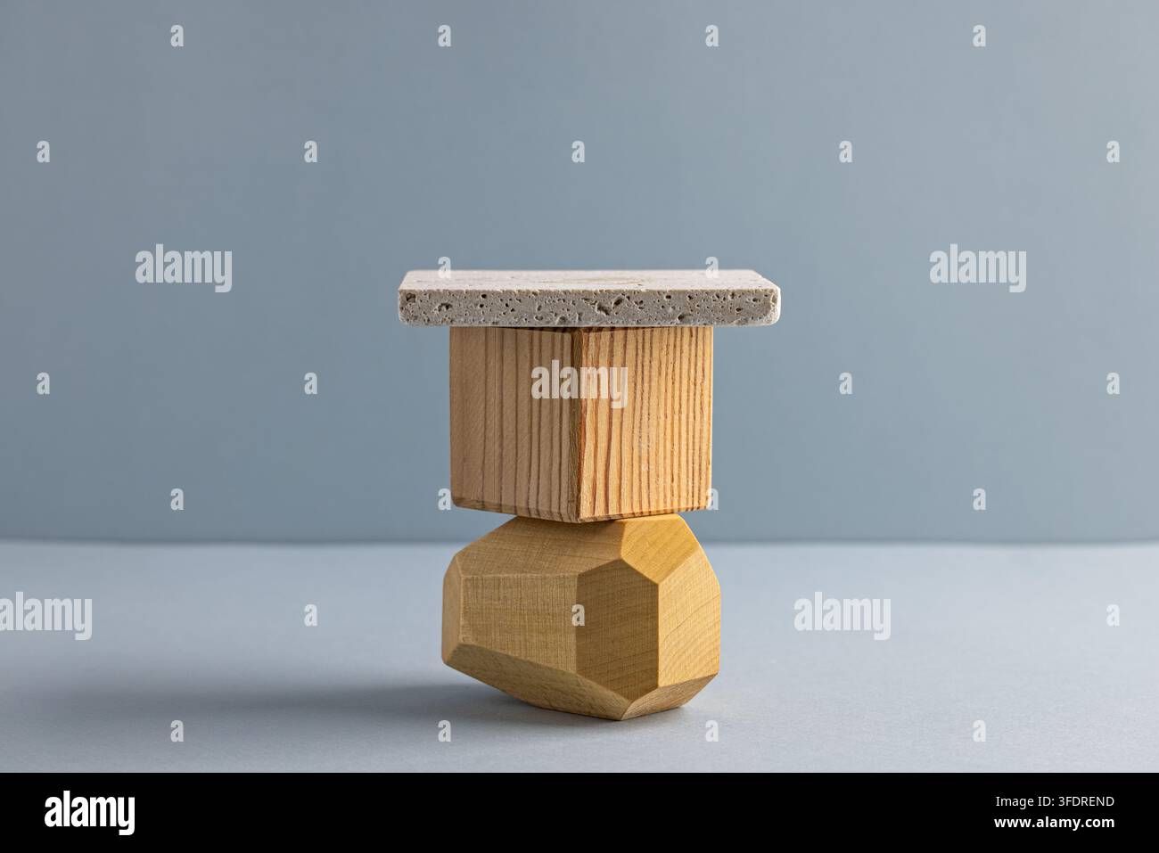 Scultura geometrica moderna in legno con elemento in cemento su sfondo grigio Foto Stock
