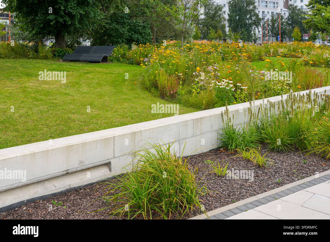 Verde fluviale urbano con prato di fiori selvatici e paesaggio moderno nel centro città di Liepaja, Lettonia Foto Stock