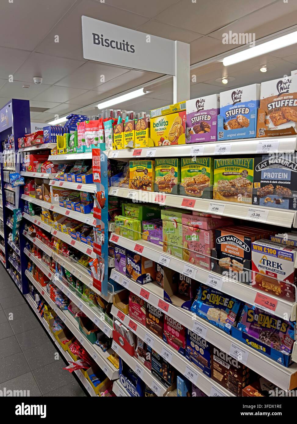 Scaffali del reparto biscotti all'interno di un supermercato Sainsbury's Local, che illustra la vendita al dettaglio di generi alimentari e gli acquisti di cibo quotidiani Foto Stock