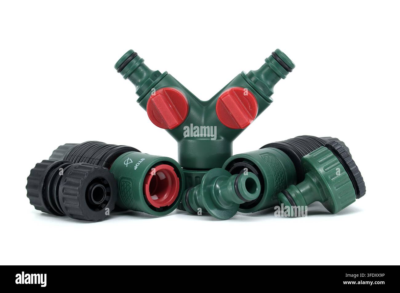 Un insieme di connettori per tubo da giardino in plastica verde e rossa e uno split Y progettato per una gestione efficiente del flusso d'acqua nei sistemi di irrigazione all'aperto Foto Stock