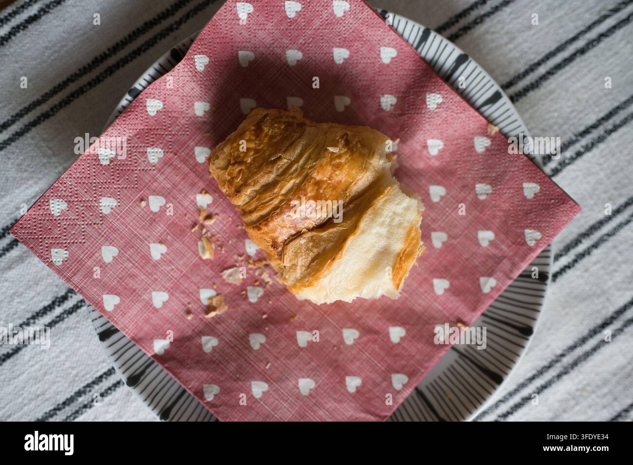 Croissant fresco con briciole su un tavolo Foto Stock