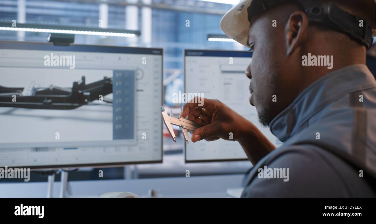 Ingeniero verifica le dimensioni di un componente lavorato rispetto al modello CAD su monitor, combinando la misurazione fisica con la tecnologia del gemello digitale per la produzione robotizzata, il prototipaggio, la metrologia e il design. Foto Stock