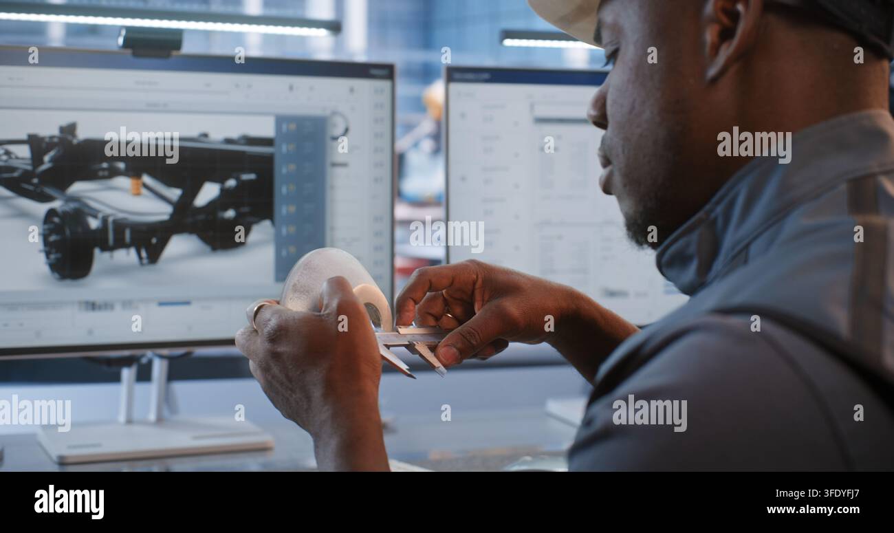 Ingeniero verifica le dimensioni di un componente lavorato rispetto al modello CAD su monitor, combinando la misurazione fisica con la tecnologia del gemello digitale per la produzione robotizzata, il prototipaggio, la metrologia e il design. Foto Stock