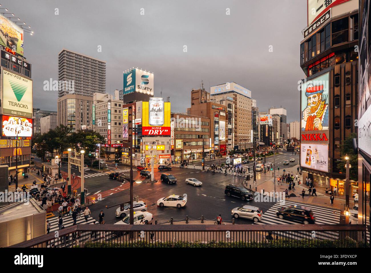 Susukino, Sapporo. Paesaggio stradale al crepuscolo con insegna Nikka Whisky e pubblicità al neon Asahi Superdry nel quartiere dello intrattenimento Foto Stock