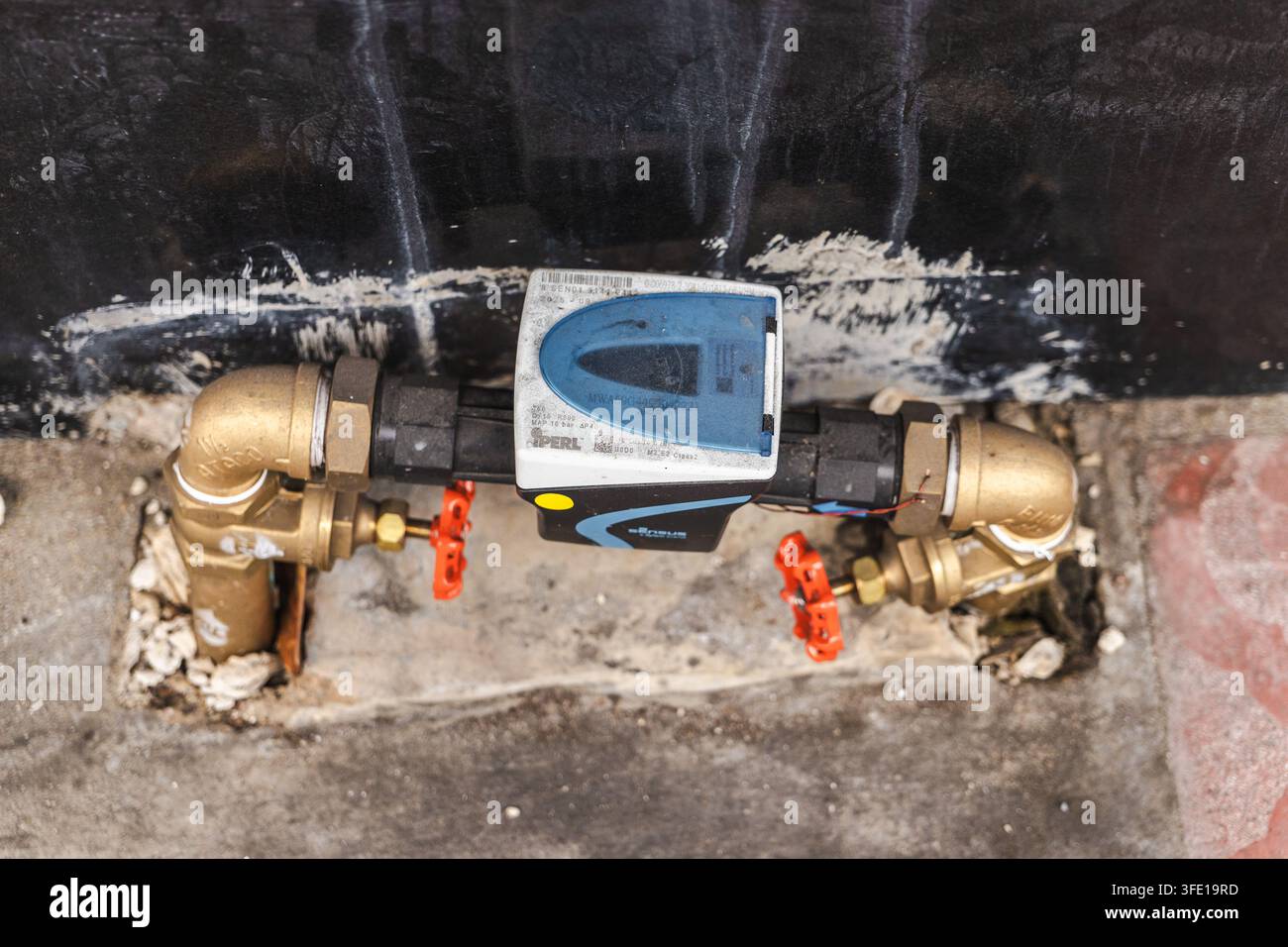 Contatore dell'acqua per esterni e valvole in ottone su un muro consumato di Bangkok Foto Stock