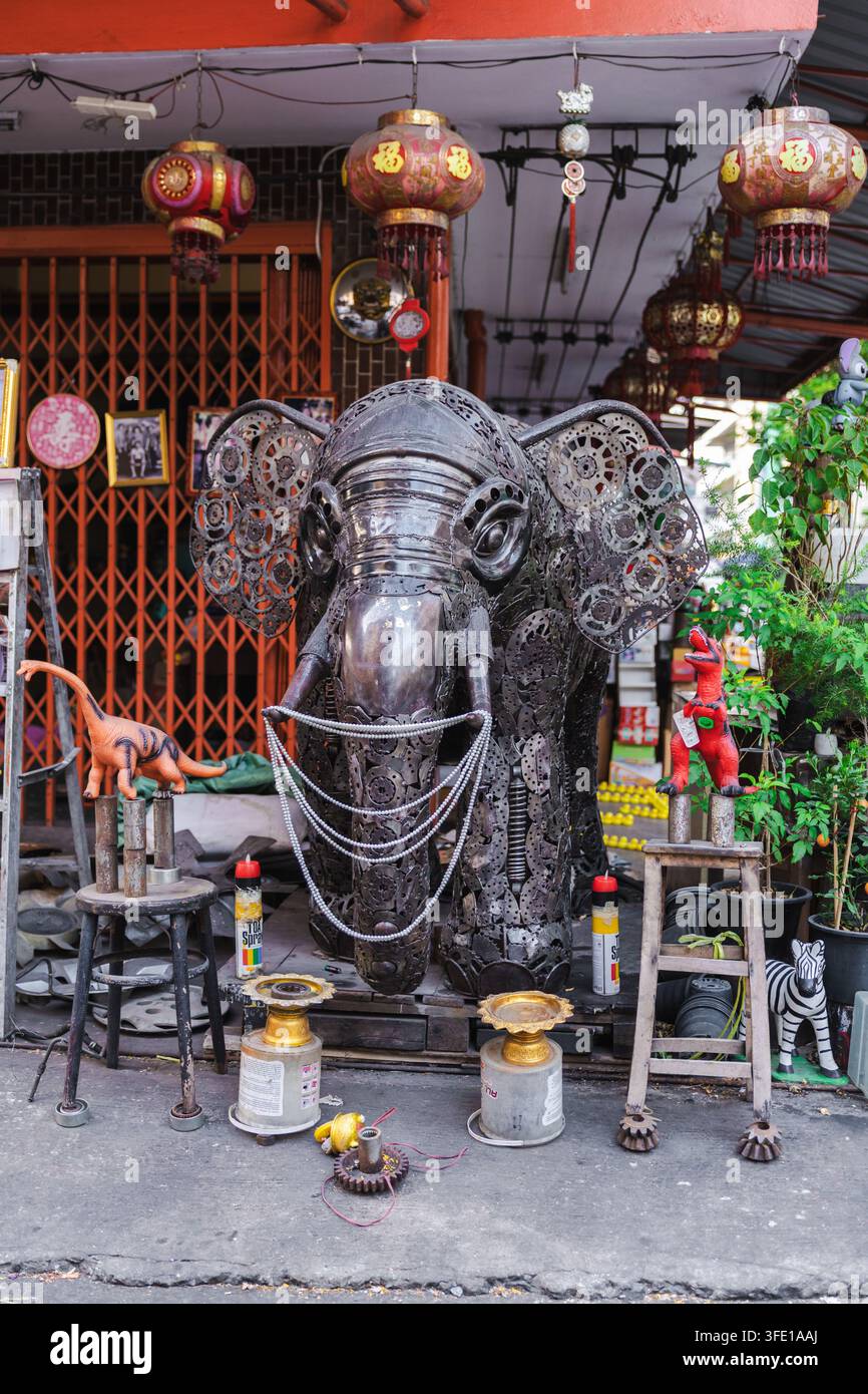 Scultura di elefante in metallo riciclato fuori da un negozio decorato con lanterne a Bangkok Foto Stock