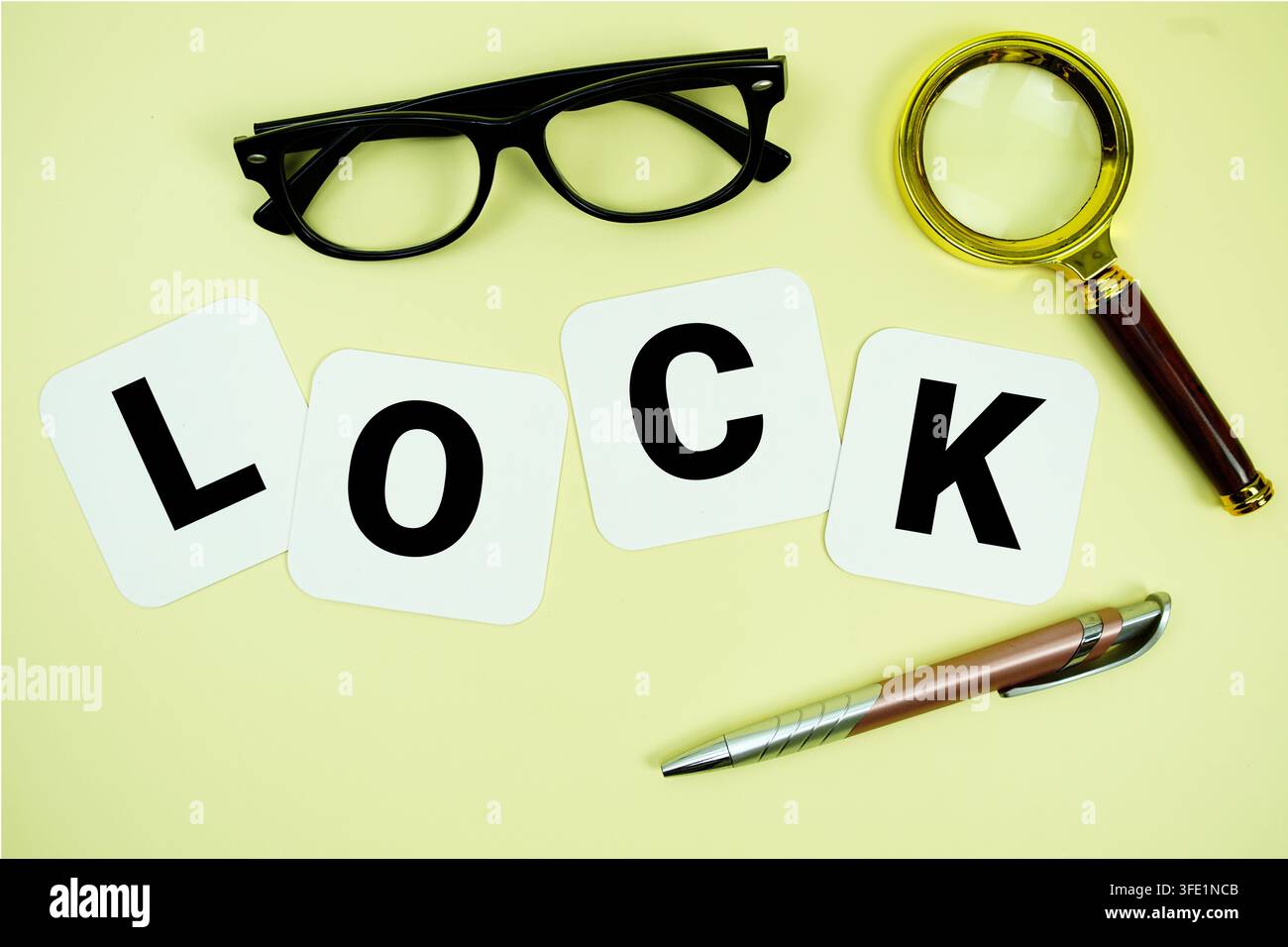 Lettere dell'alfabeto LOCK con lente d'ingrandimento, occhiali e penna su sfondo giallo Foto Stock