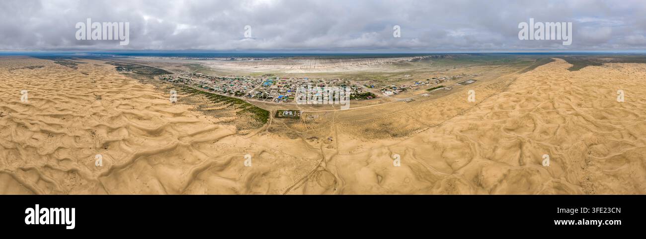 Vista aerea del villaggio di Senek circondato da vaste dune di sabbia e da un paesaggio desertico arido nella regione di Mangystau, Kazakistan. Foto Stock