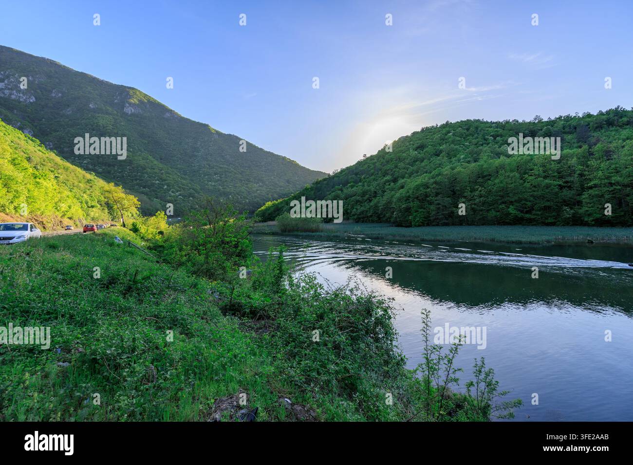 Bellissima catena montuosa con un fiume che la attraversa. L'acqua è calma e il cielo è sereno Foto Stock