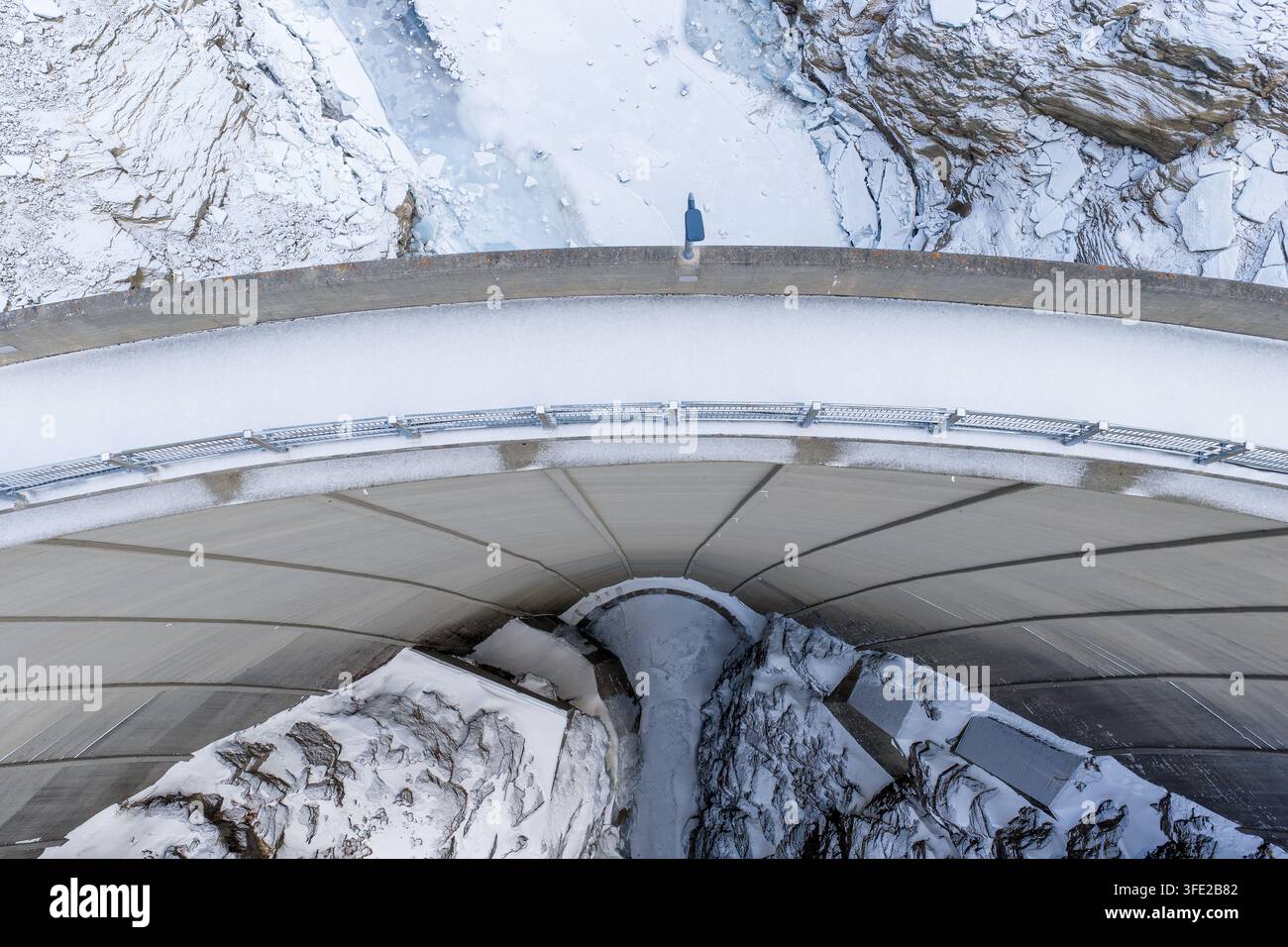 Vista aerea della struttura del diga in cemento circondata da montagne innevate e terreno ghiacciato a Tafjord, More og Romsdal, Norvegia. Foto Stock