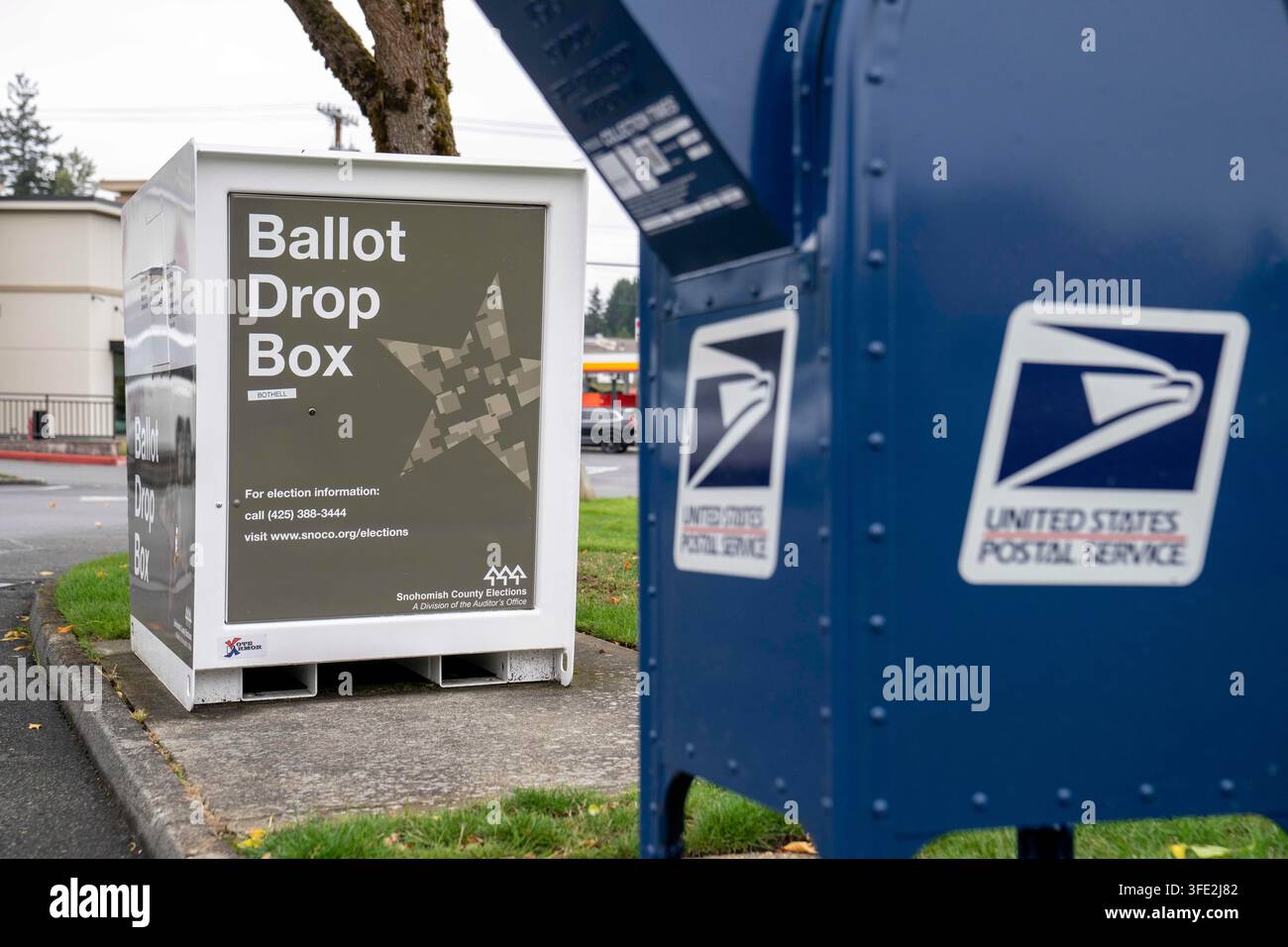 Bothell, Washington, USA. 1 set., 2026. Una cassetta di raccolta USPS blu si trova accanto a una cabina per il deposito delle schede elettorali della contea di Snohomish al margine di un parcheggio a Bothell, Washington, USA, martedì 1 settembre 2026. Oltre il 98% degli elettori dello stato di Washington utilizza il sistema di voto per posta, anche se una grande percentuale di elettori utilizza cabine per il deposito delle schede elettorali come questa invece di inviarle tramite il servizio postale. La fessura per l'inserimento ha un cartello "chiuso" perché non è in corso un'elezione attiva. L'amministrazione Trump ha cercato di limitare il voto per posta attraverso ordini esecutivi e nuove regole su come le Foto Stock