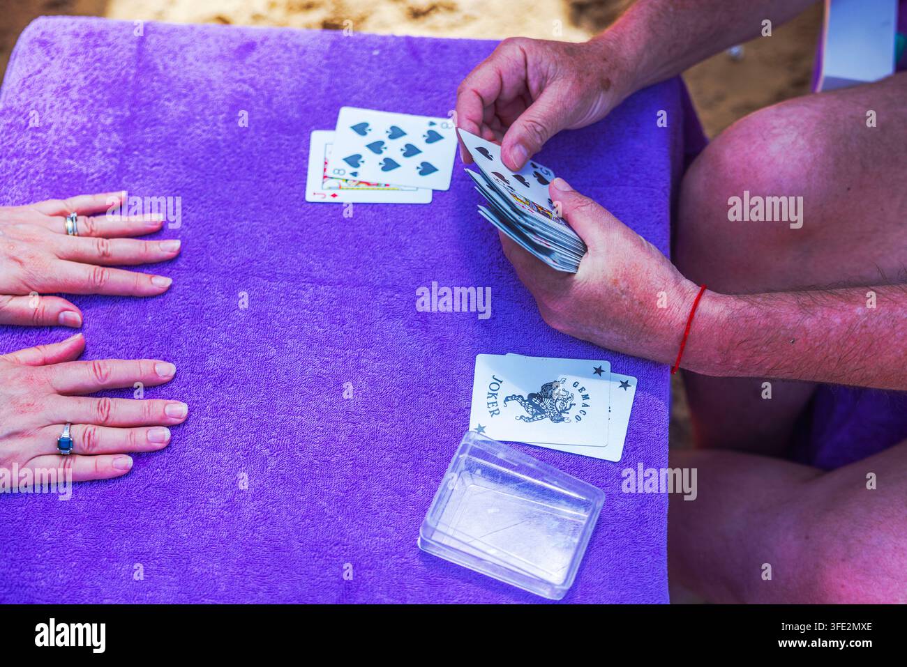 Prima vista di un uomo che distribuisce carte da gioco durante una partita con una donna al tavolo. Repubblica Dominicana. Punta Cana. Foto Stock