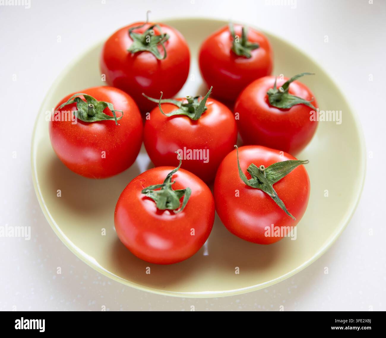 Gruppo di pomodori interi su un piatto Foto Stock