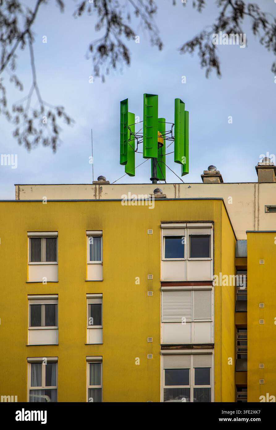 Mini centrale eolica sul tetto di una casa in pannelli in città Foto Stock