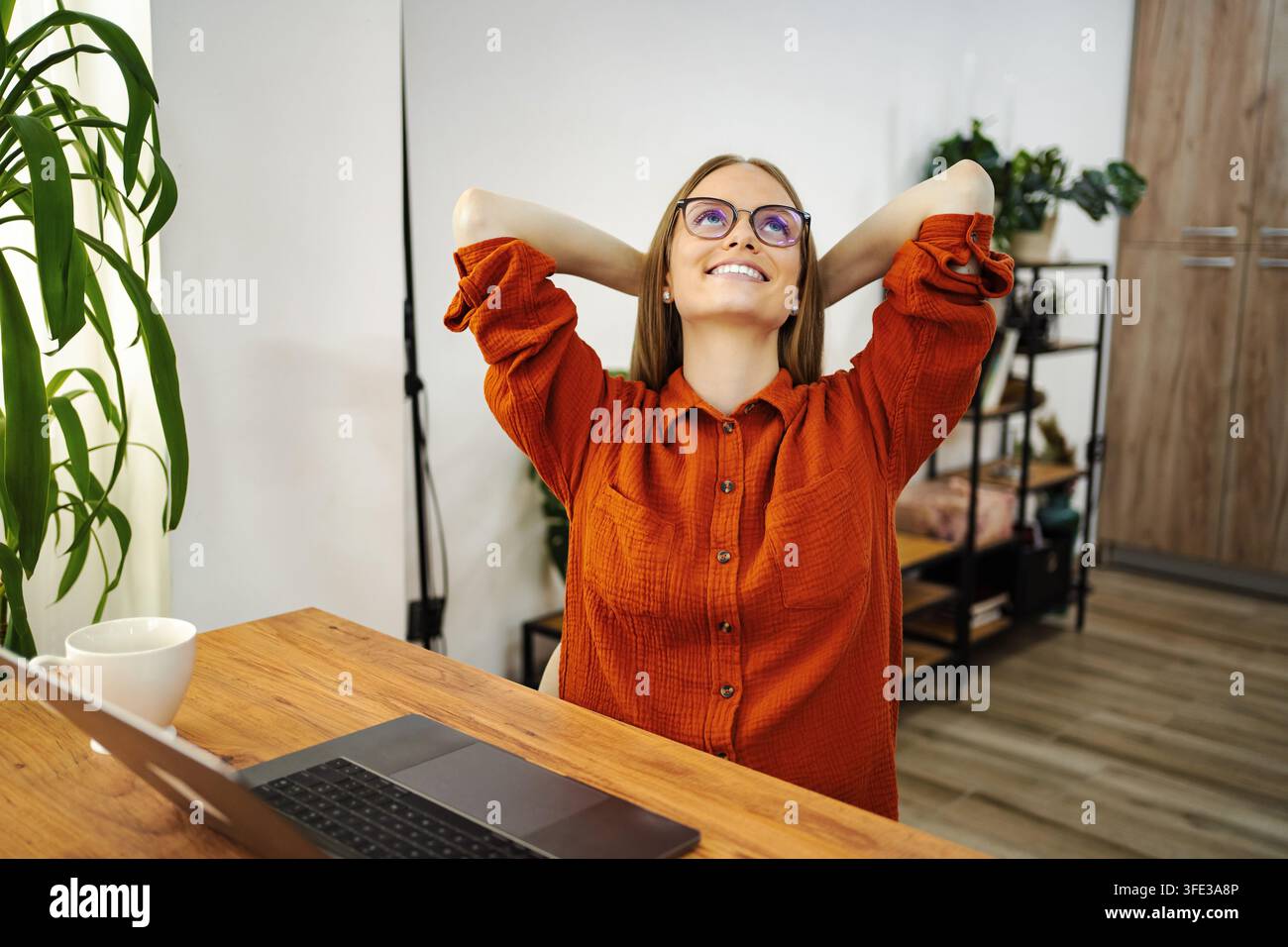 Giovane donna che si rilassa dopo il lavoro in ufficio a casa Foto Stock