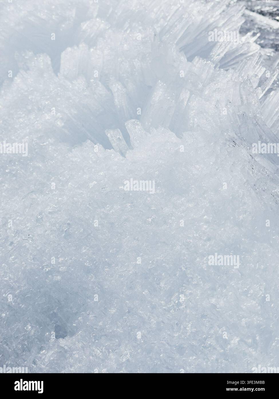 Un macro primo piano di cristalli di ghiaccio affilati come aghi e schegge ghiacciate che formano uno splendido motivo geometrico Foto Stock