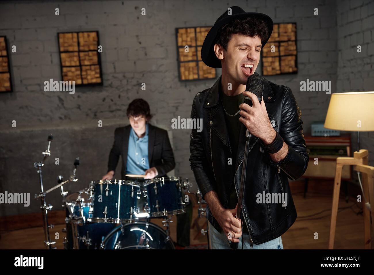 Gruppo rock che si esercita con emozione intensa e atmosfera in stile vintage Foto Stock