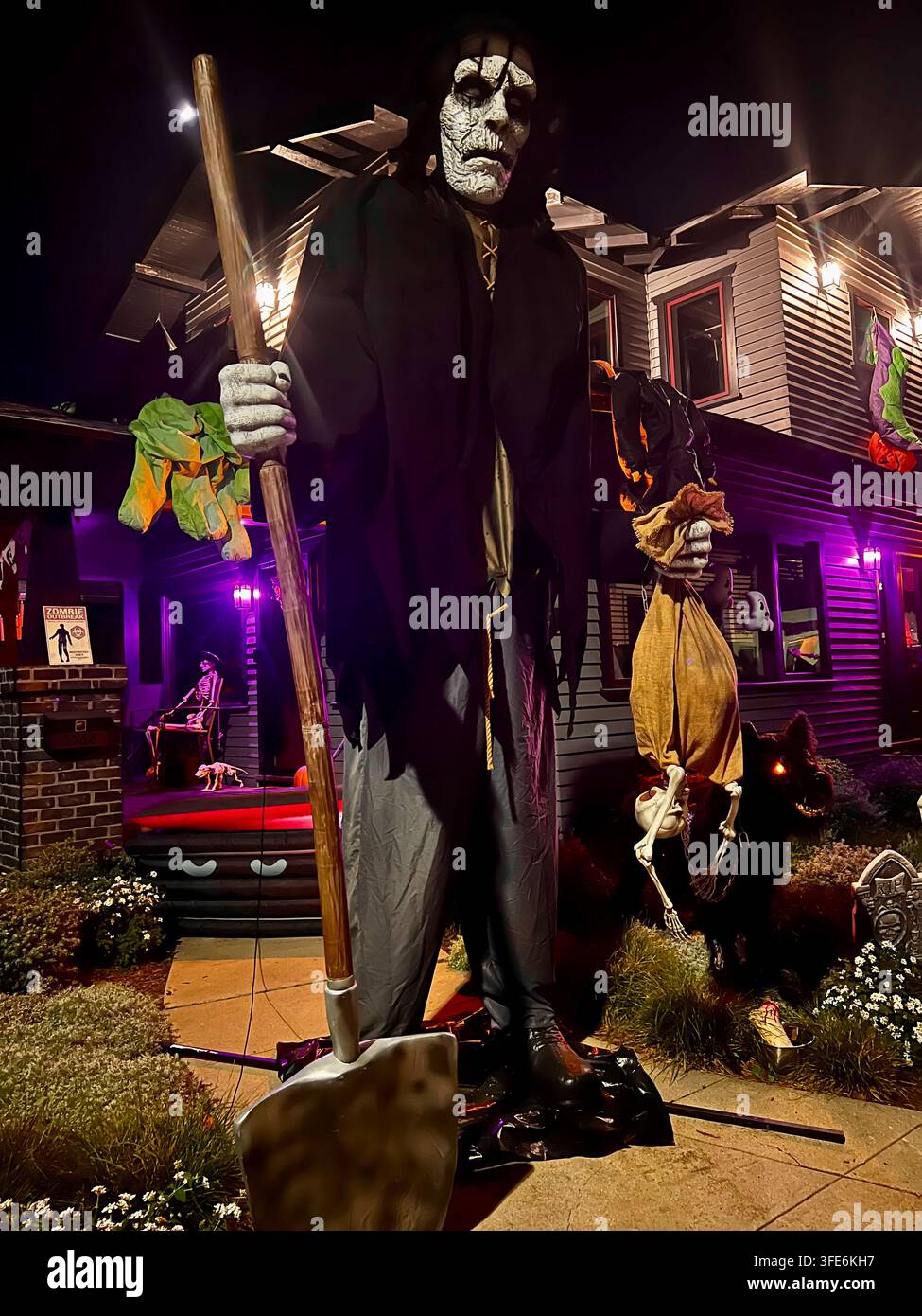 SAN DIEGO, CA - 28 OTTOBRE 2025: Una figura gigante di becchino alta 12 piedi che tiene una pala, posizionata davanti a una casa per una mostra di Halloween. Foto Stock