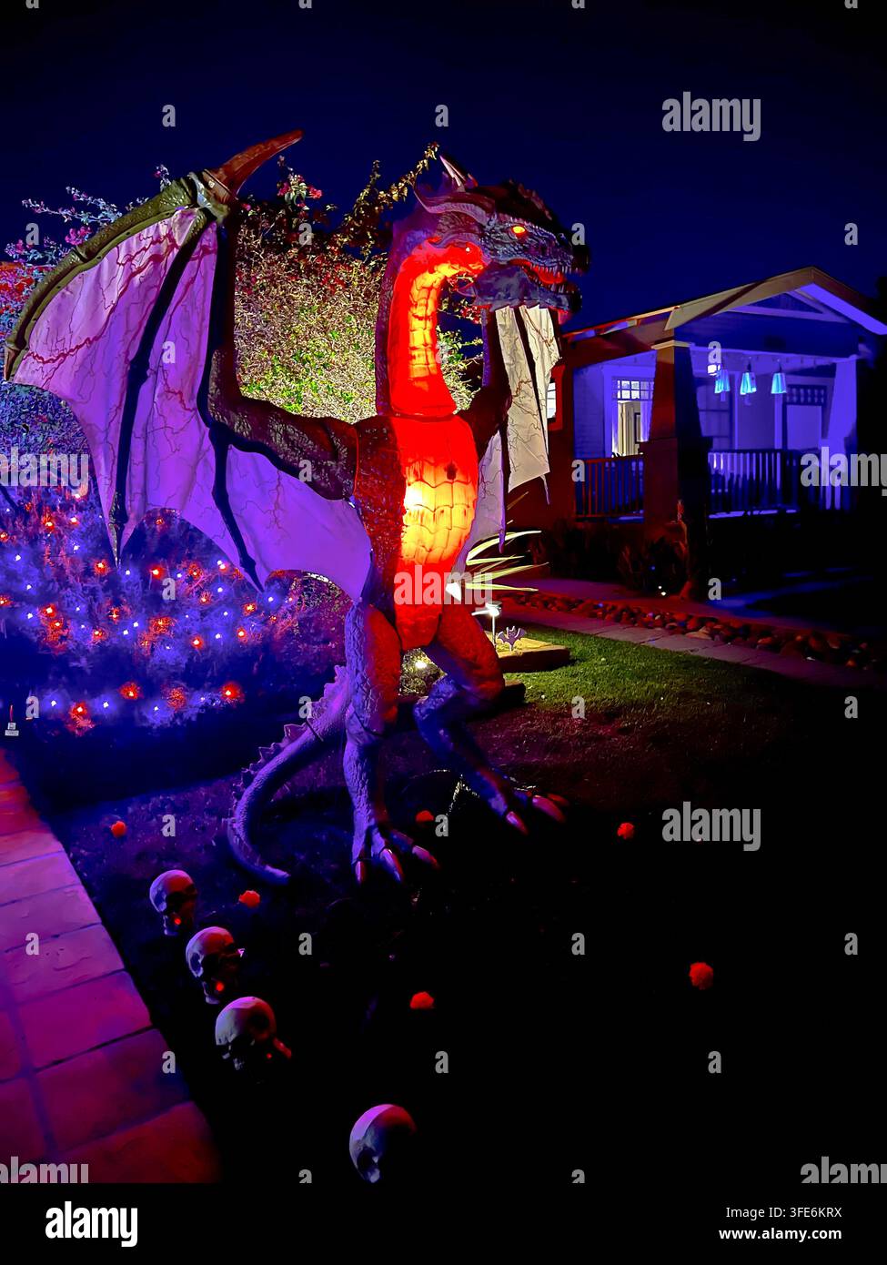 SAN DIEGO, CA - 28 OTTOBRE 2025: Una massiccia figura di drago gigante con ali spiegate che brillano con illuminazione interna rossa e viola in una periferia fro Foto Stock