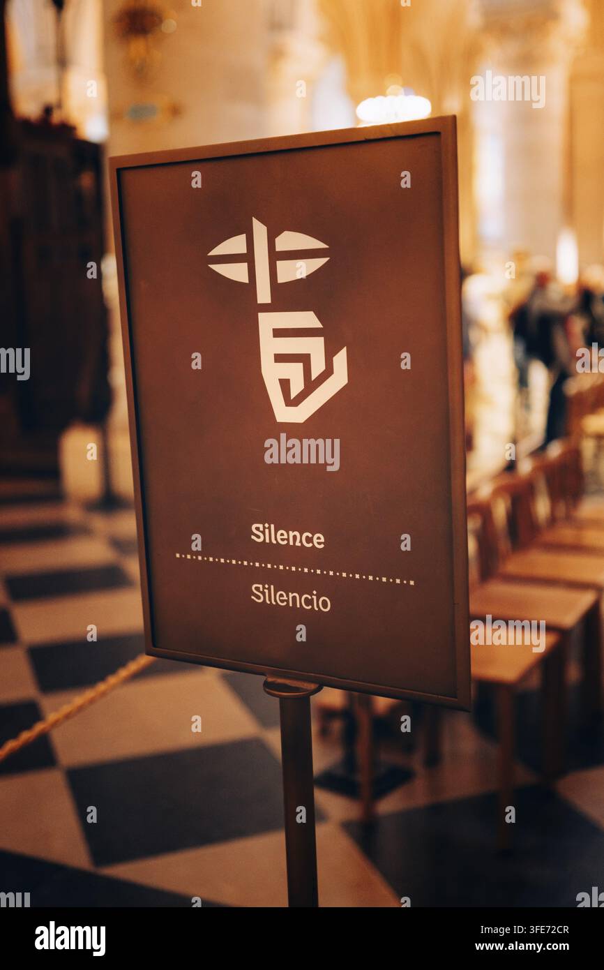 Segnale informativo nella Cattedrale di Notre Dame con l'iscrizione Silence e Silencio e un simbolo stilizzato della pace, un puntatore davanti alla bocca, Pa Foto Stock