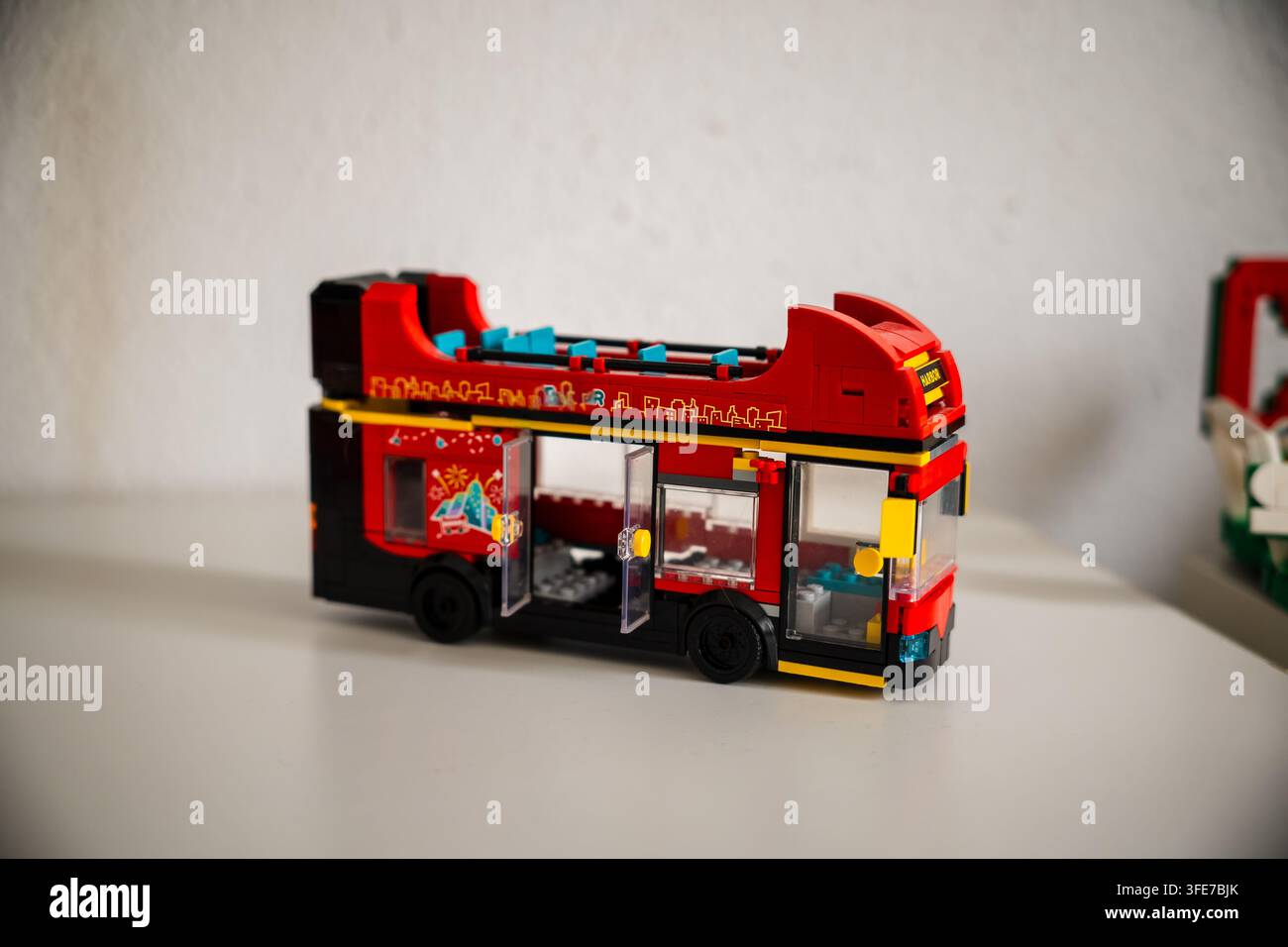 Modello di autobus di Londra in Lego che mostra un design a due piani aperto, costruito da un set di mattoncini di plastica rossi esposto su una superficie bianca del tavolo. Foto Stock