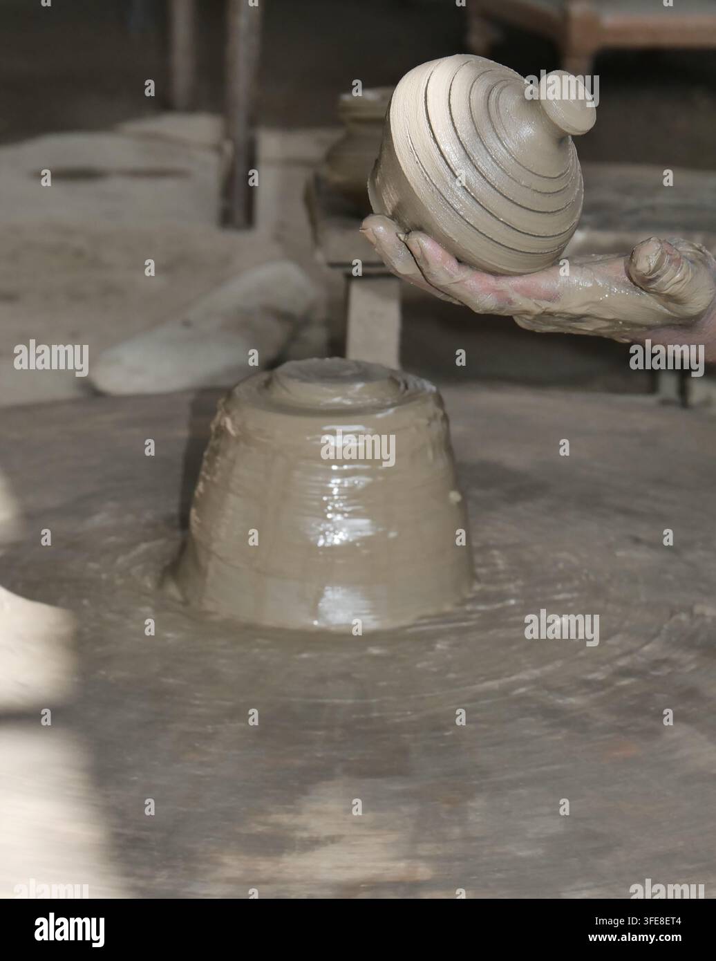 Produzione di ceramica con ruota da vasaio e argilla bagnata nel laboratorio. Foto Stock