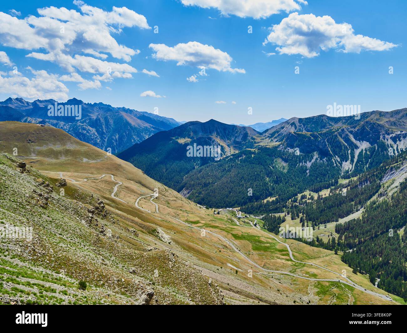 Valle alpina con strada tortuosa e picchi impervi — Paesaggio panoramico di alta montagna Foto Stock