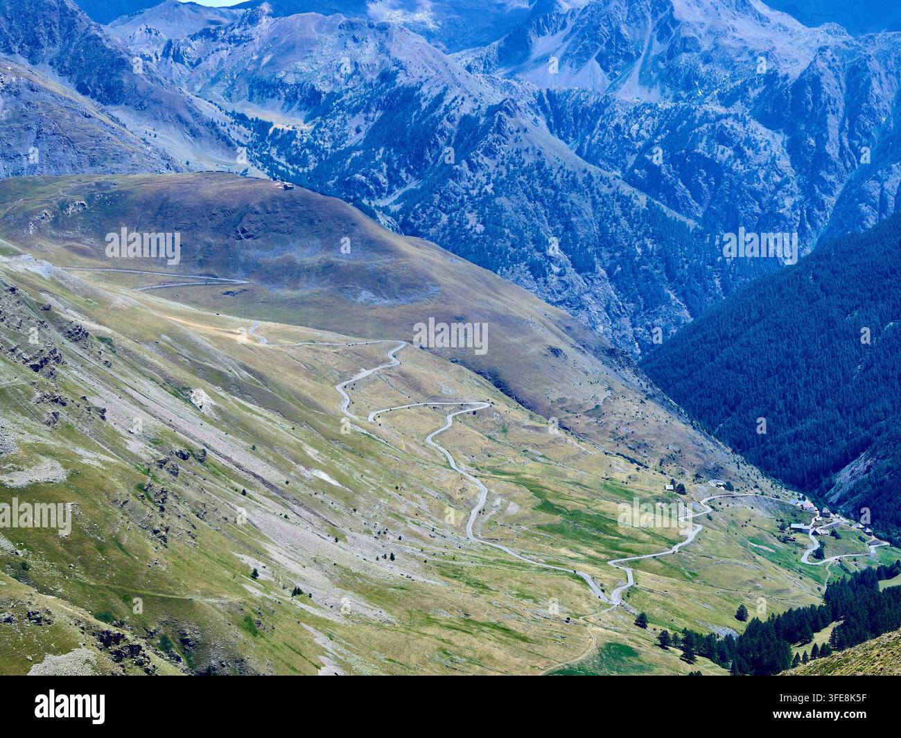 Valle alpina con strada tortuosa e picchi impervi — Paesaggio panoramico di alta montagna Foto Stock