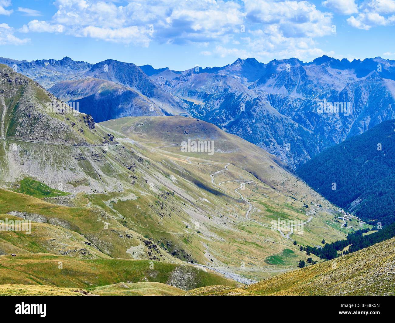 Valle alpina con strada tortuosa e picchi impervi — Paesaggio panoramico di alta montagna Foto Stock
