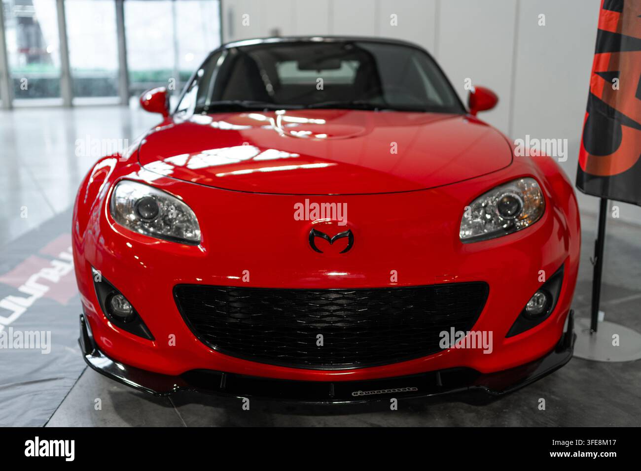 Milano, Italia - 12.11.2022: Auto sportiva rossa Mazda MX-5 Miata del 2015 in un contesto espositivo indoor. Esposizione Milano Autoclassica Foto Stock